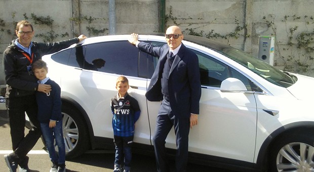 I fratelli Mauro e Gianluigi Piccinini in posa davanti a un modello di auto Tesla, durante l’inaugurazione